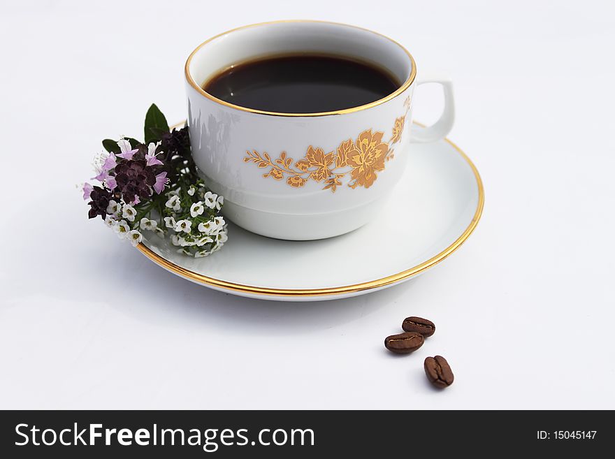 Cup with coffee on saucer and flowerses on white background