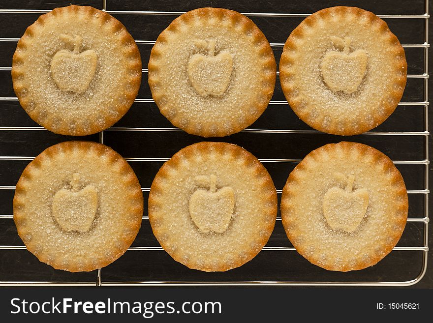 Six Apple Pies on a cooling tray with aslate background