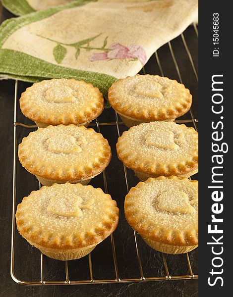 Six Apple Pies on a cooling tray with a slate background