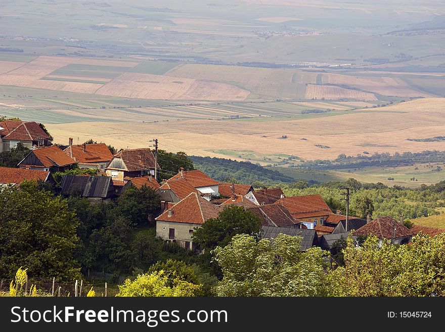 Mountain village Jina in Transylvania Romania on hill top with highland cultivated land in background. Mountain village Jina in Transylvania Romania on hill top with highland cultivated land in background