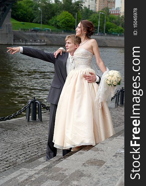 Newly married couple looking away in the same direction which is pointed by groom. Newly married couple looking away in the same direction which is pointed by groom