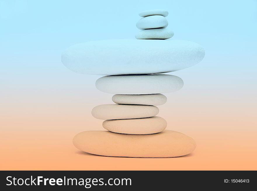 Stack of smooth stones over orange and white background. Stack of smooth stones over orange and white background