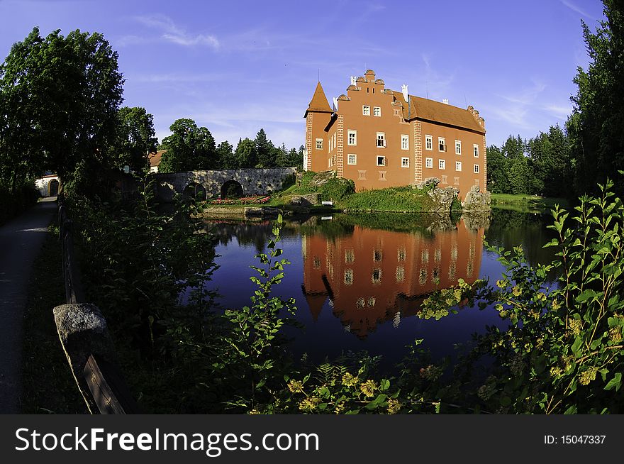 The red chateau of Cervena Lhota in Czech Republic with water reflection taken with fish eye lens. The red chateau of Cervena Lhota in Czech Republic with water reflection taken with fish eye lens