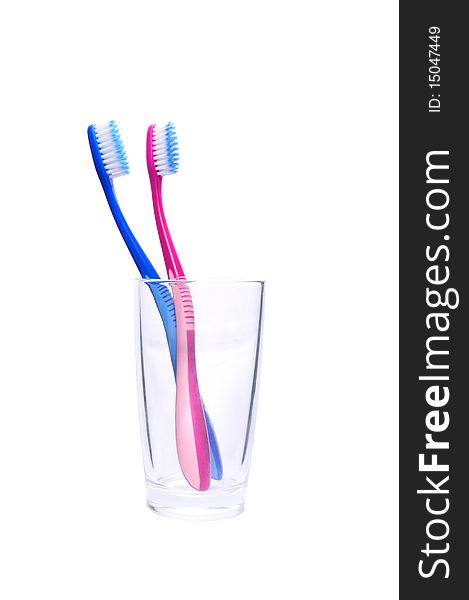 Isolated blue and pink toothbrushes in the glass. Isolated blue and pink toothbrushes in the glass