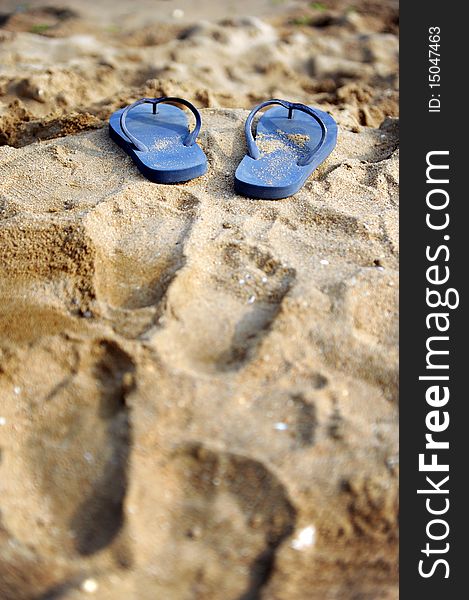 A pair of blue flip flops on the beach. A pair of blue flip flops on the beach