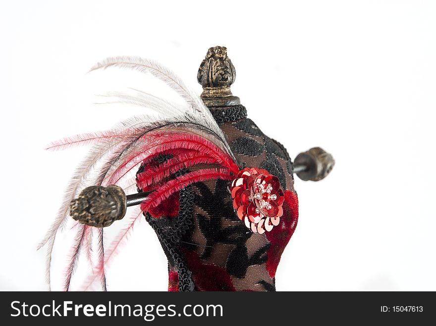 Black and red jewelry holder with feathers on a white background