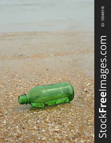 The Green empty Bottle lay on beach. The Green empty Bottle lay on beach