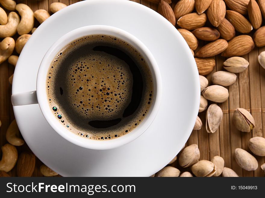 Delicious coffee with nuts on the background. Delicious coffee with nuts on the background