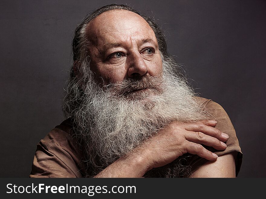 Old man sixty, seventy, with a long beard with big smile on a dark background