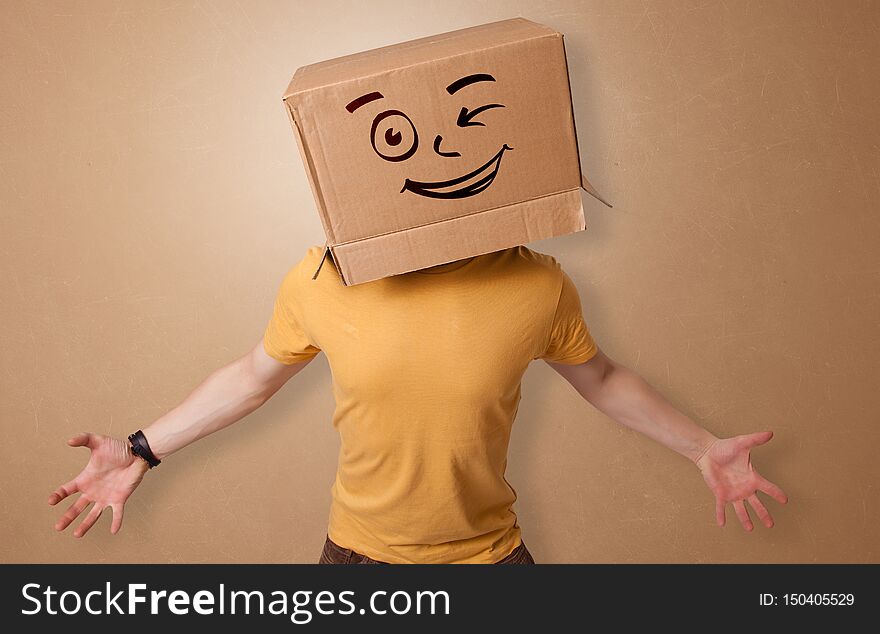 Handsome man standing and gesturing with a carton box on his headn. Handsome man standing and gesturing with a carton box on his headn