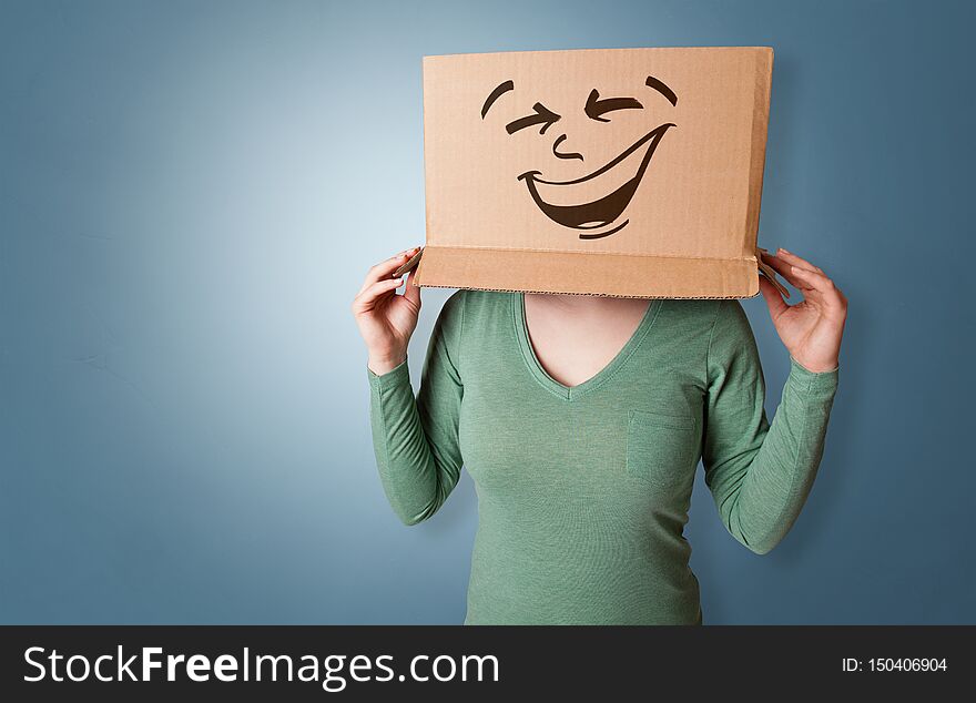 Young girl standing and gesturing with a cardboard box on her headn. Young girl standing and gesturing with a cardboard box on her headn