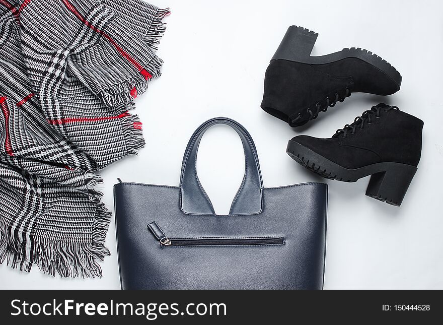 Women&#x27;s clothes, shoes and accessories on a white background. Suede boots, bag, scarf. Flat lay. Women&#x27;s clothes, shoes and accessories on a white background. Suede boots, bag, scarf. Flat lay