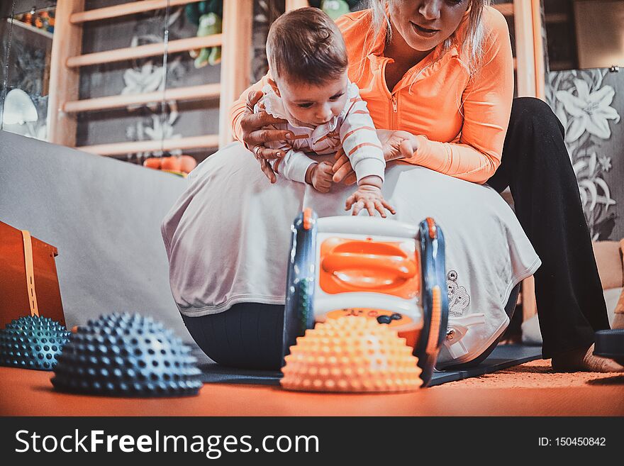 Expirienced pegiatrist is doing special exercises for cute little toddler