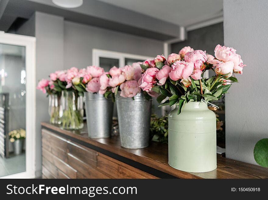 The counter of the flower shop. Pink peonies in a metal vase. Beautiful peony flower for catalog or online store. Floral