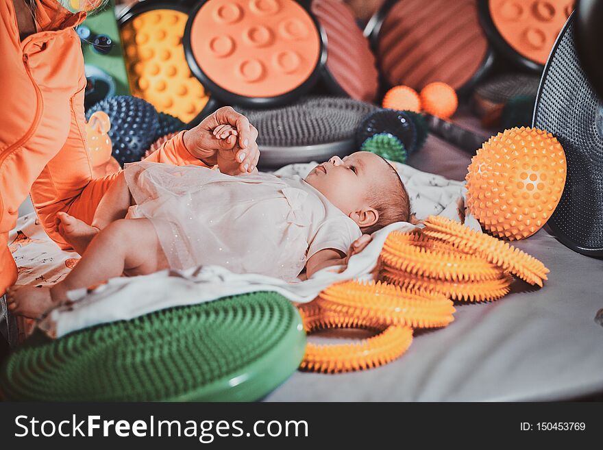 Happy expirienced masseur is doing massage with special ortophedic toy for little baby. Happy expirienced masseur is doing massage with special ortophedic toy for little baby.