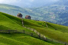 Landscape Of A Raw Green Meadow With Leading Lines To Barns, Bucovina, Romania. Royalty Free Stock Photography