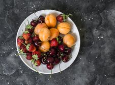 Fresh Ripe Fruit - Apricots, Cherries, Strawberries On A Dark Background, Top View Stock Image