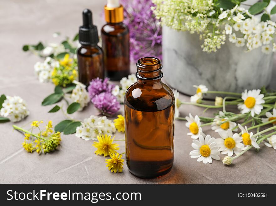 Composition with bottles of essential oils with flowers