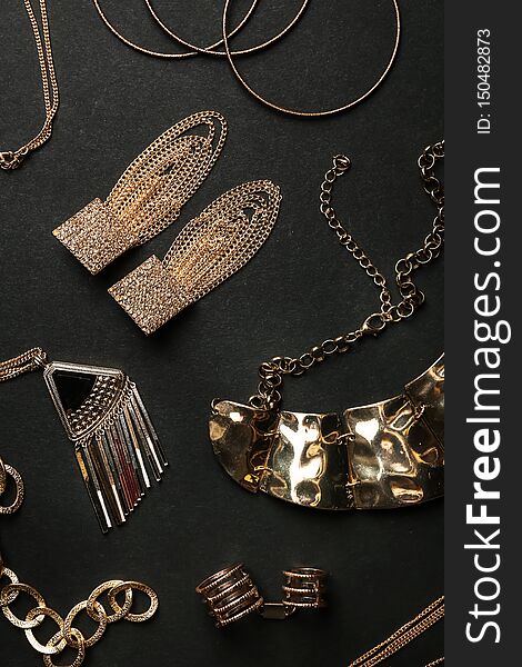Set of gold jewelry on black background