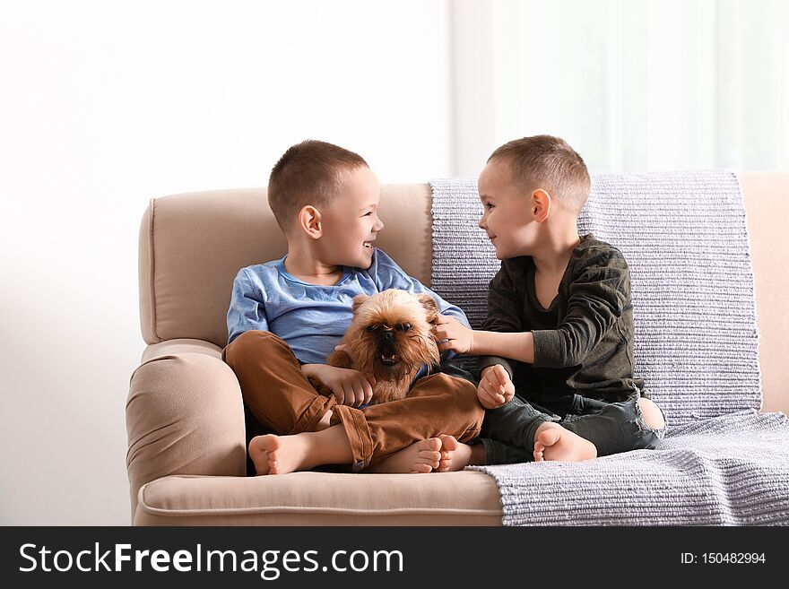 Portrait of cute boys with funny Brussels Griffon dog at home. Loyal friends