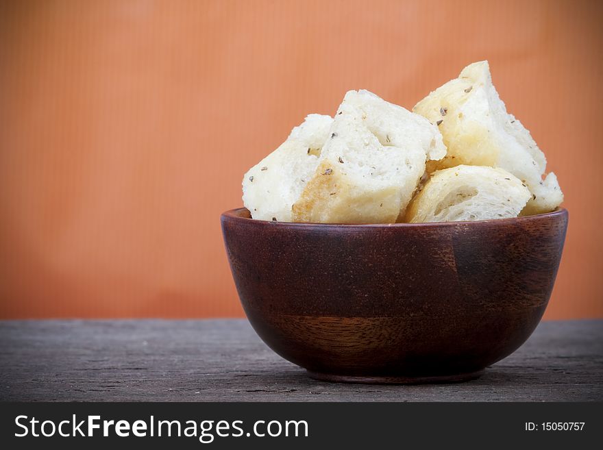 Croutons in a wooden bowl on a slate counter with copy space. Croutons in a wooden bowl on a slate counter with copy space.