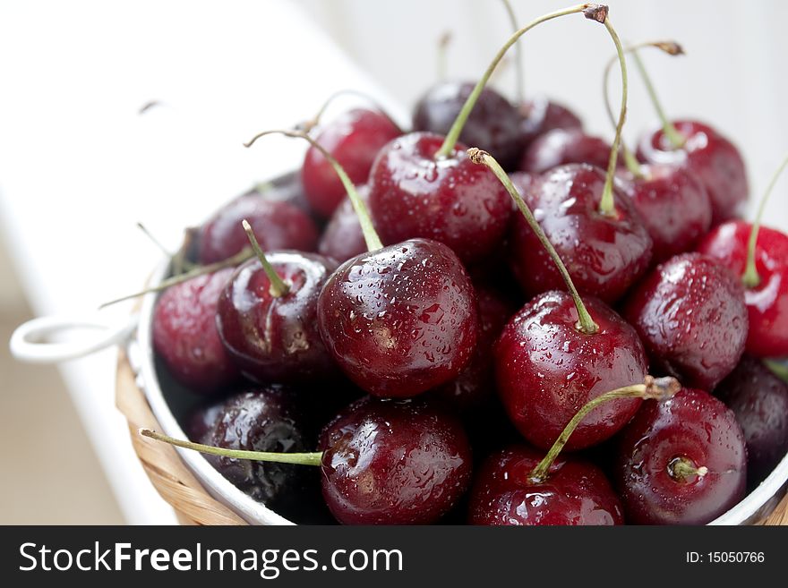 Wet ripe red sweet cherries in a bowl with limited focus. Wet ripe red sweet cherries in a bowl with limited focus.