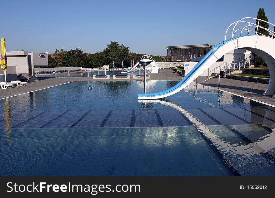 Dispeopled bath pool with white slide