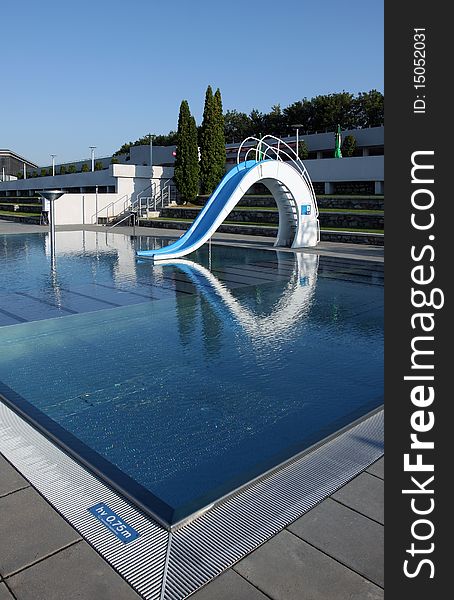 Dispeopled bath pool with white slide