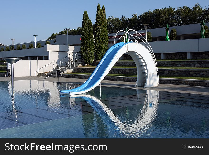 Dispeopled bath pool with white slide