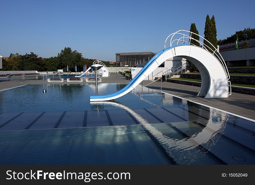 Dispeopled bath pool with white slide