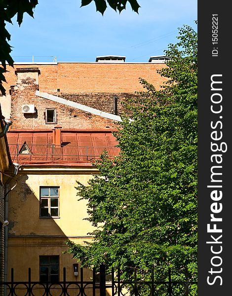 The part of wall with windows. Tree and blue sky. The part of wall with windows. Tree and blue sky.