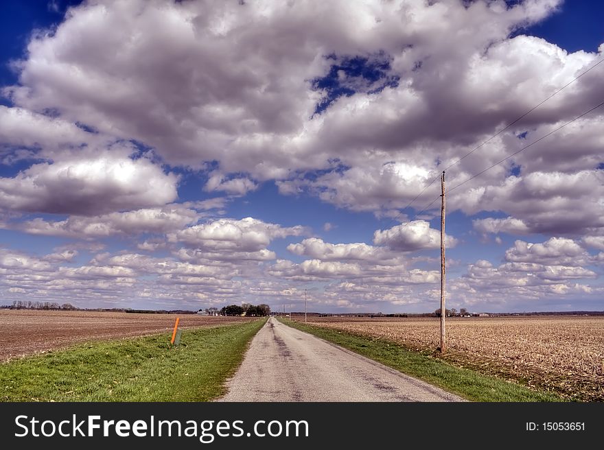 Bare Fields And Road Under Clouds