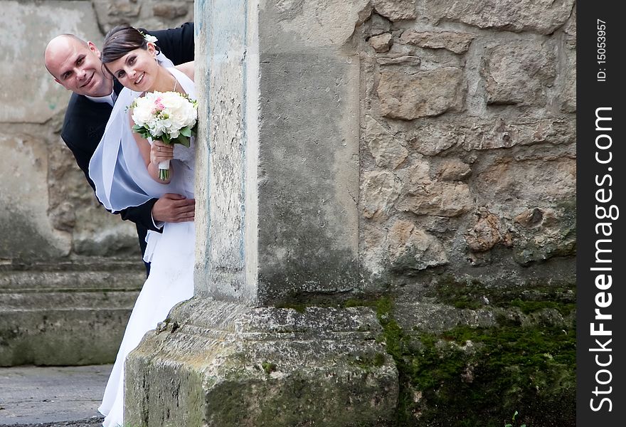 Beautiful bride and groom posing among old church walls