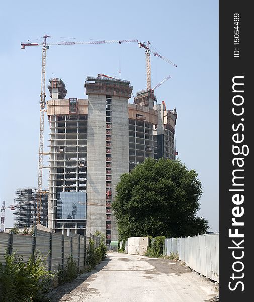 Construction site in Milan (Italy) for the construction of a skyscraper, with many cranes at work. Construction site in Milan (Italy) for the construction of a skyscraper, with many cranes at work.