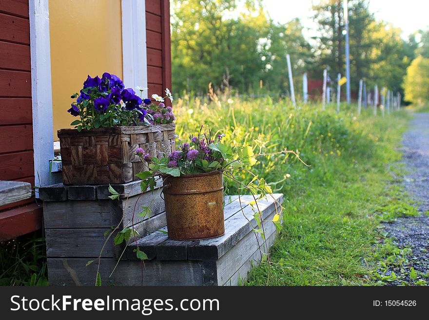 Pots and baskets with flowers outside old house. Pots and baskets with flowers outside old house