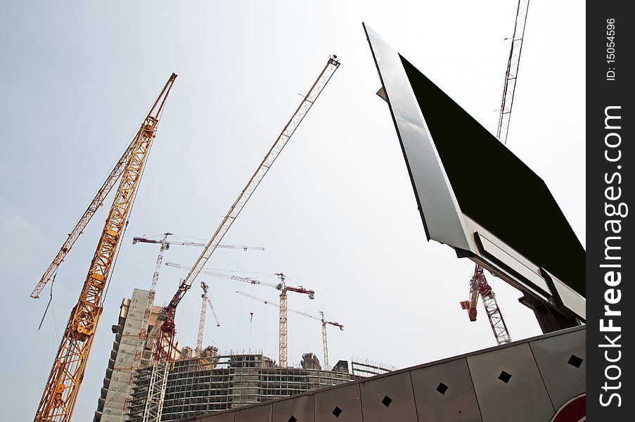 Construction site in Milan (Italy) for the construction of a skyscraper, with many cranes at work. Construction site in Milan (Italy) for the construction of a skyscraper, with many cranes at work.