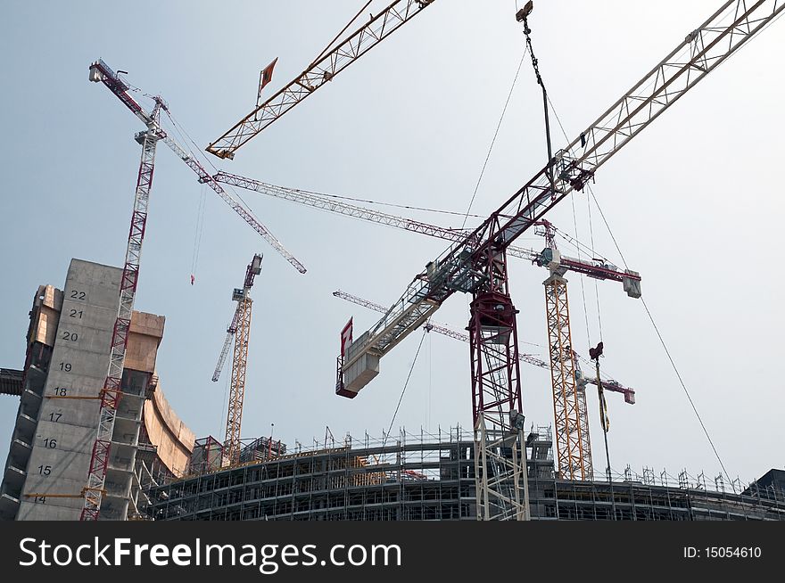 Construction site in Milan (Italy) for the construction of a skyscraper, with many cranes at work. Construction site in Milan (Italy) for the construction of a skyscraper, with many cranes at work.