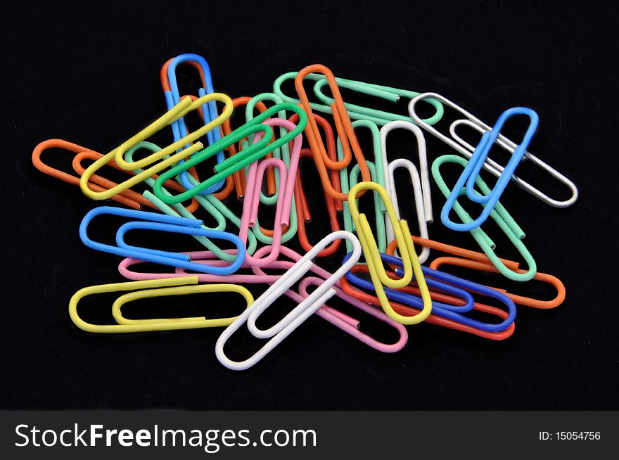 Pile of Colored Paperclips on Black background
