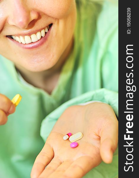 Woman holds pills in a hand inside of hospital