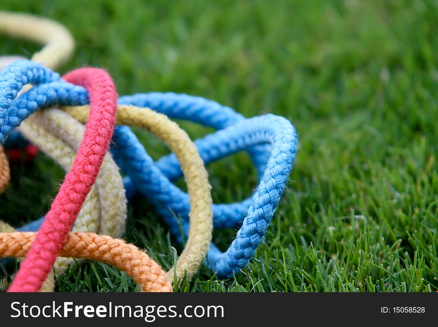 Colorful gymnastics ropes lying in grass. Colorful gymnastics ropes lying in grass