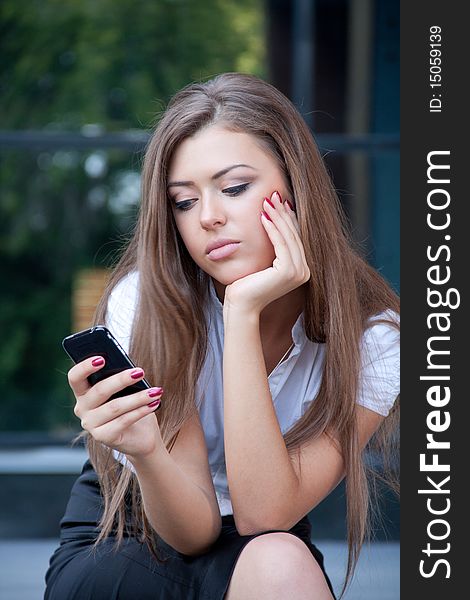 Young Woman Looks In Phone And Longs