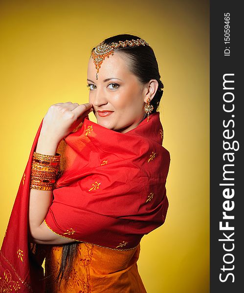 Young beautiful woman in indian traditional style. yellow background