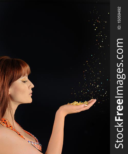 Young Beautiful Woman Blowing Golden Stardust