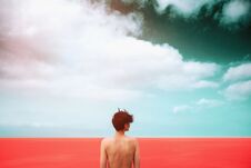 Slim Girl With A Beautiful Bare Back Is Standing On The Living Coral Sea. Dark Sky With Clouds. Unity With Nature. Freedom. Life Royalty Free Stock Photo