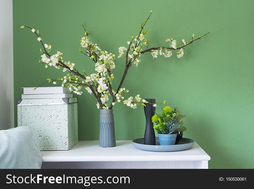 Beautiful flower in a vase on green wall in living corner at home