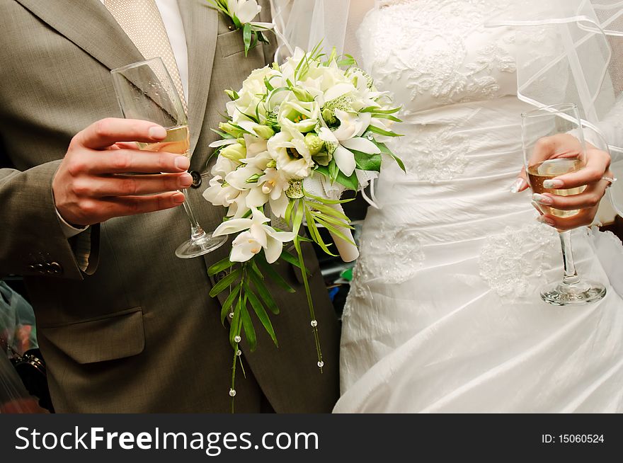 Closeup of a bride & groom holding glasses with champagne