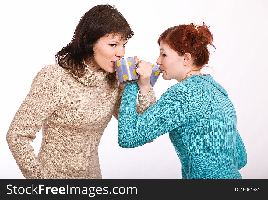 Two young beautiful girls drink coffee. Two young beautiful girls drink coffee