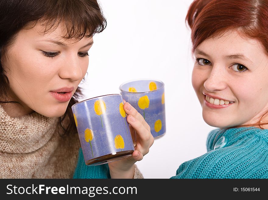 Two young beautiful girls drink coffee. Two young beautiful girls drink coffee