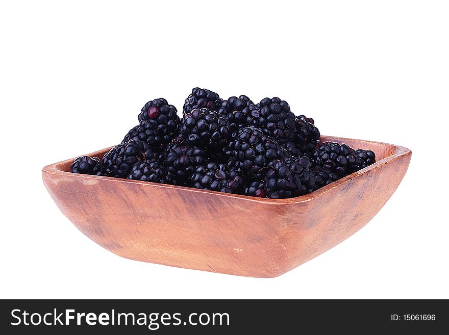 Blackberry - berries of black colour in a wooden plate on a white background. Blackberry - berries of black colour in a wooden plate on a white background.