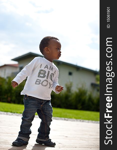 Young afro american baby playing around in the garden. Young afro american baby playing around in the garden.